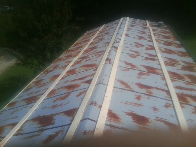 Rusted metal roof panels with new wood purlins before replacement — Storm Damage Roof Repair in Colchester by Roofing Brothers